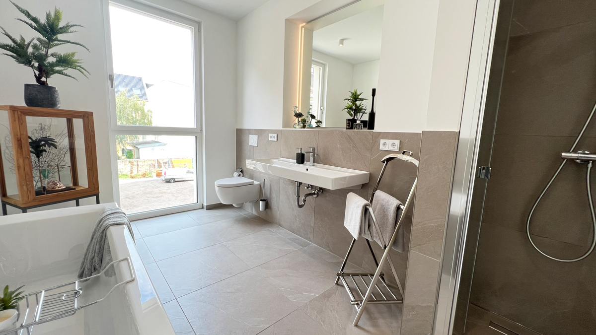 Modernes Bad mit großformatigen Fliesen, Tageslicht, Walk-in-Dusche und stilvoller Ausstattung im Wohnprojekt Beletage Buckau.