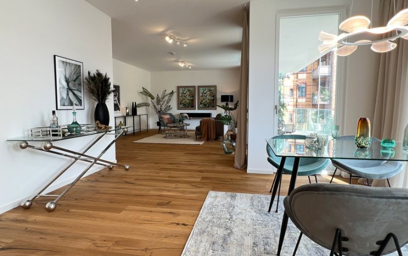 Offener Wohn-Essbereich mit hochwertiger Möblierung, Parkettboden und Designleuchte in exklusivem Ambiente.
