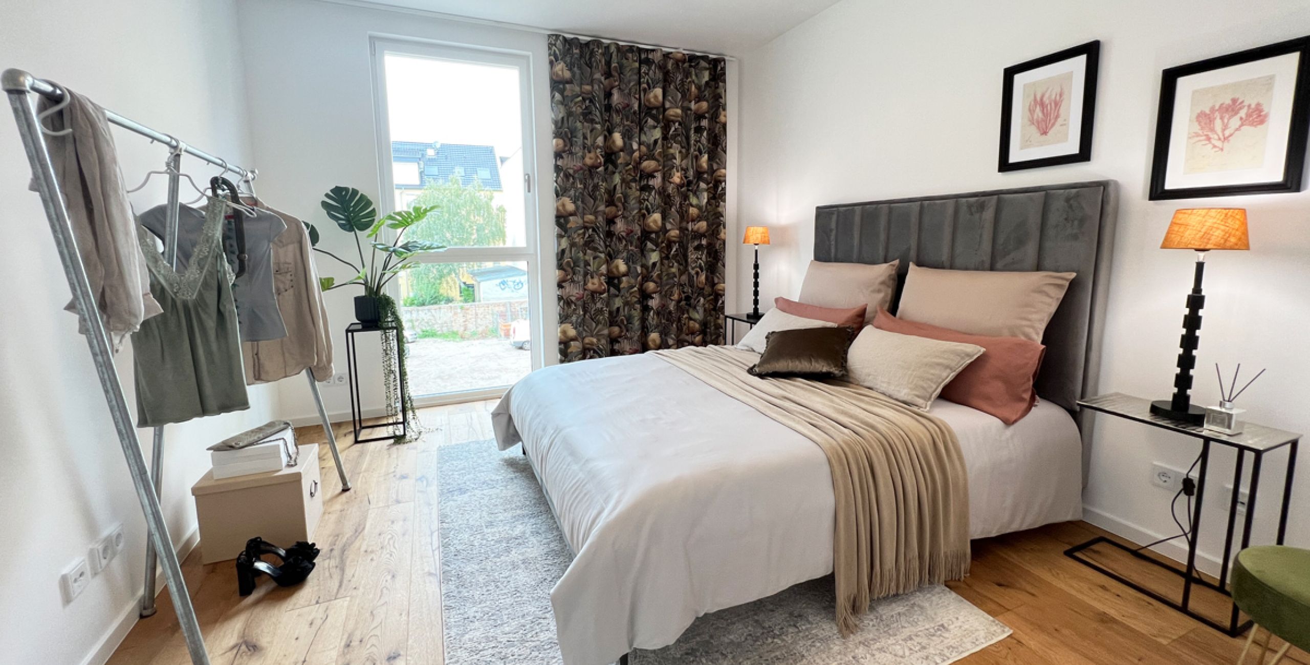 Stilvolles Schlafzimmer mit Designerbett, floralen Akzenten, Parkettboden und großem Fenster für entspanntes Wohnen in Buckau.