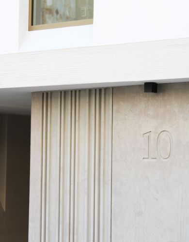 Architektonisches Fassadendetail mit moderner Betonstruktur und eleganter Hausnummer 10.