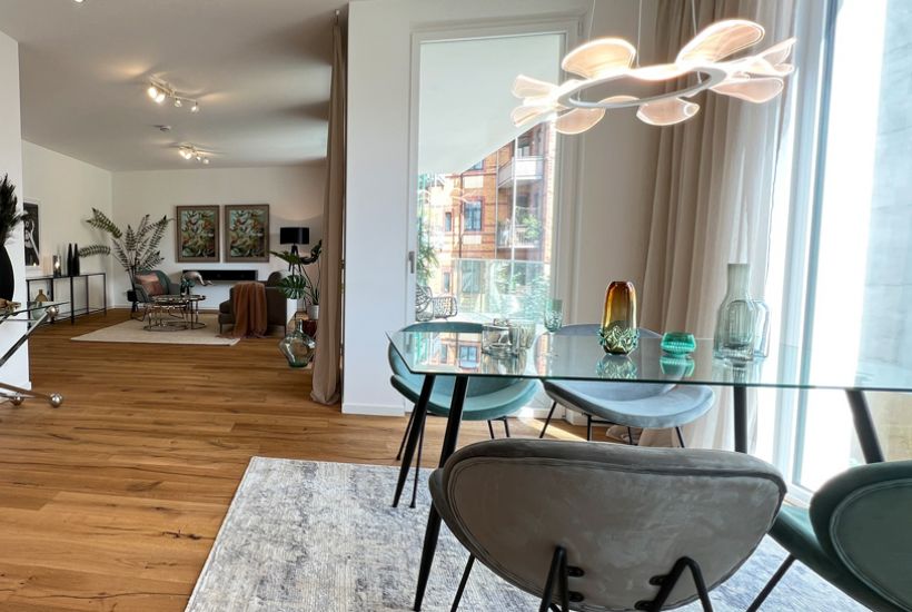 Offener Wohn-Essbereich mit hochwertiger Möblierung, Parkettboden und Designleuchte in exklusivem Ambiente.