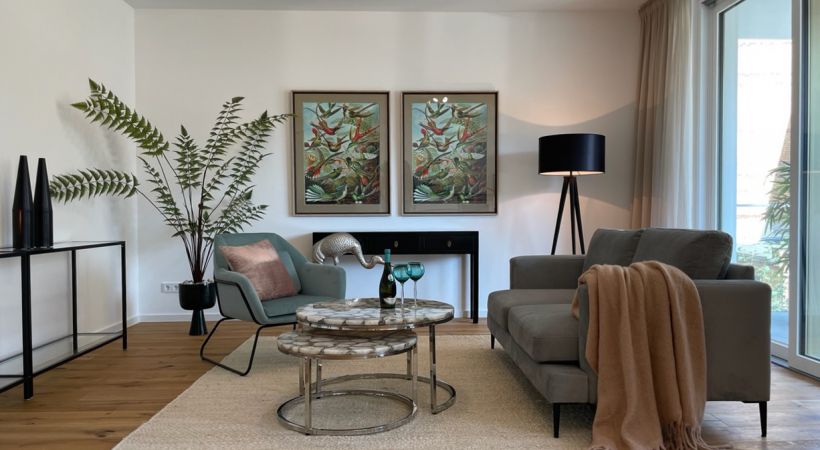 Stilvoll eingerichtetes Wohnzimmer mit Designer-Couch, Kunstmotiven, Naturholzboden und edler Beleuchtung in Buckau.