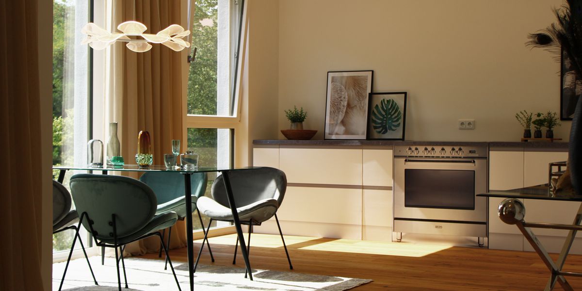 Lichtdurchfluteter Essbereich mit Designmöbeln, Glasleuchte und moderner Einbauküche im stilvollen Wohnambiente von Beletage Buckau.