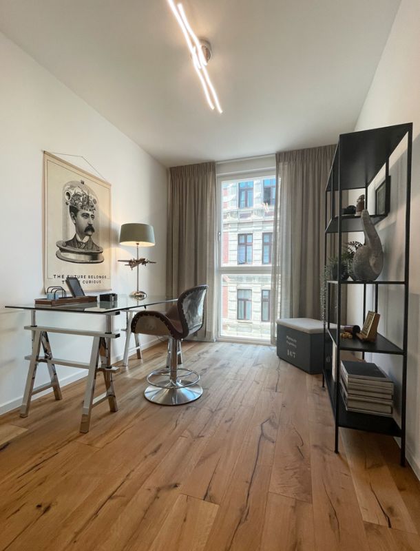 Modernes Homeoffice mit Designmöbeln, Eichenparkett und großem Fenster für stilvolles Arbeiten zu Hause.